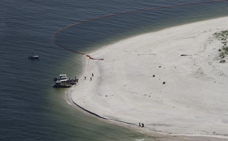 Mens robotten under vand arbejder med saven, har folk på kysten nu i ugevis kæmpet for at forhindre olien i at nå op på stranden. Her er vi i Mississippi. 