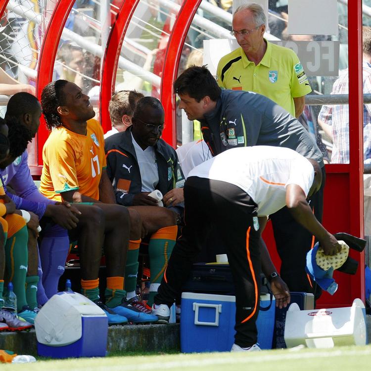 smertefuldt. Didier Drogba bliver behandlet på bænken efter det voldsomme frispark, der sandsynligvis koster stjernespilleren VM-deltagelsen. 