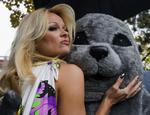 anti-pels. Pamela Anderson omfavner en sæl-maskot i forbindelse med en anti-sælpelskampagne i Canada. 