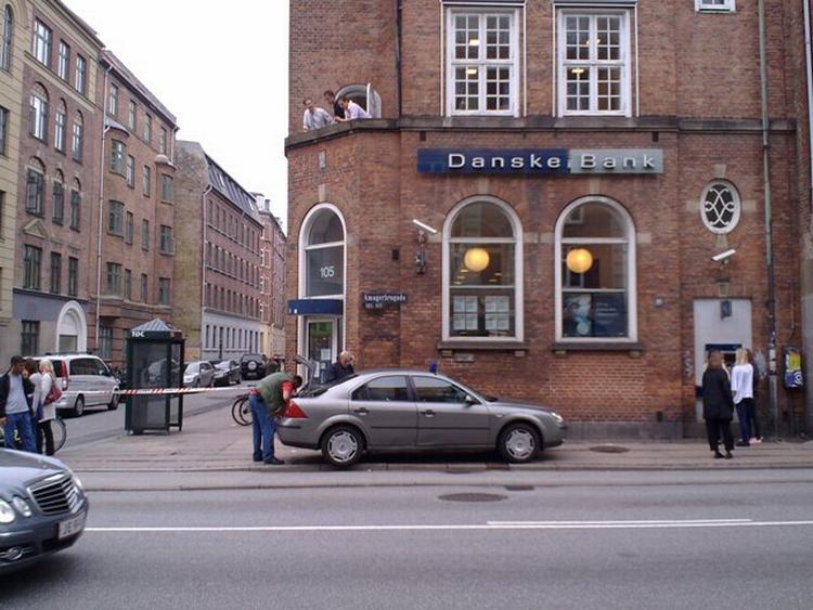 DOBBELTRØVERI. Civil politibil ud for en af de to bankfilialer, der onsdag eftermiddag fik besøg af tre - uheldige, viste det sig - røvere. 