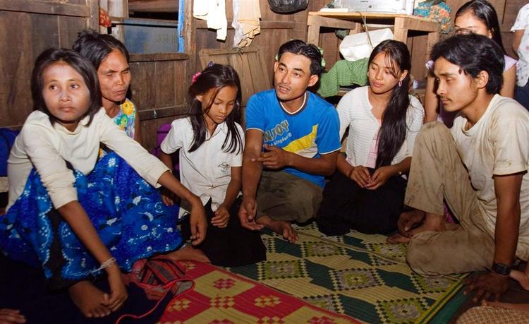 Den 27-årige cambodianske junglekvinde (yderst til venstre) sidder med - efter alt at dømme - sin familie. Kvinden har flere gange forsøgt at flygte. 