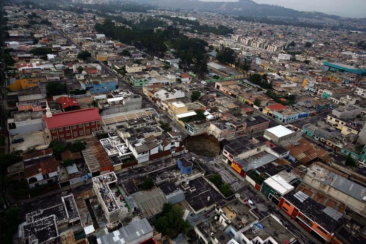 Nabolag. Beboerne nær kæmpehullet, der åbnede sig i Guatemalas hovedstad er begyndt at vende tilbage til deres huse. 