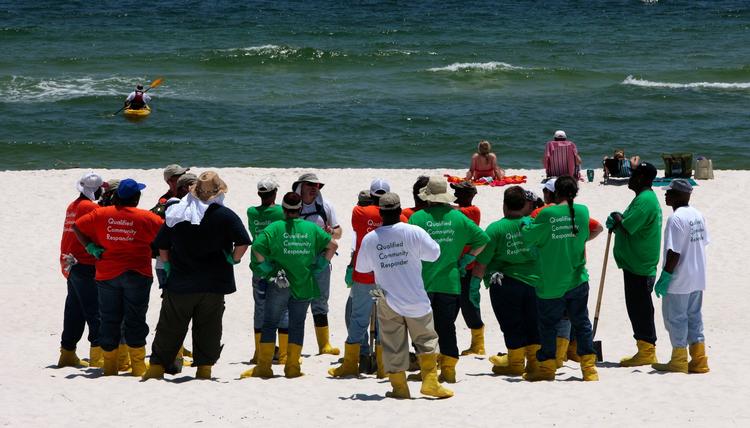 Strandvaskere. Oprydningsarbejdere hyret af BP står på stranden i Perdido Keys, Florida. Olieudslippet har fået tusindvis af frivillige til at melde sig, men BP vil kun bruge faglærte folk til at håndtere olieforureningen. 