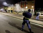 Advarsel. En sydafrikansk politibetjent skyder tåregas mod demonstranter ved VM-stadionet i Durban. 