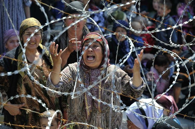 En usbekisk kvinde, der har mistet sin familie, græder mens hun venter på at krydse ingenmandsland ind til Usbekistan. 