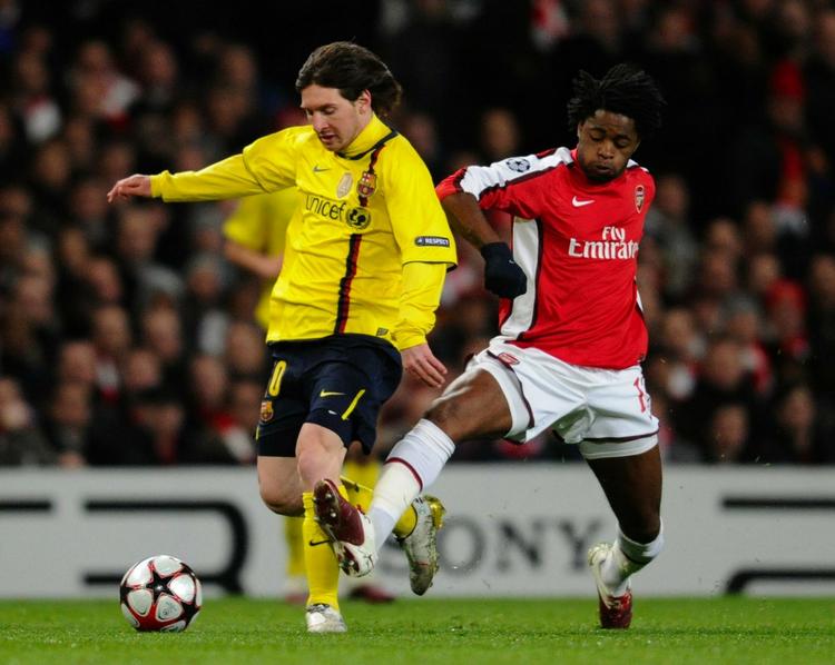 advarsel. Alex Song i hælene på Lionel Messi under opgøret mellem Arsenal og Barcelona. Arkivfoto. 