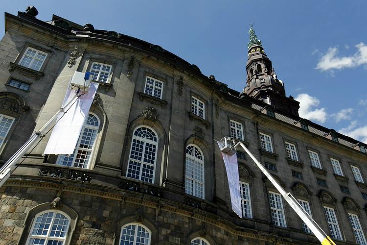 Protest.  De unge aktivister havde lejet to kraner og hejst to seks meter høje og to meter brede bannere op foran vinduerne bag talerstolen i folketingssalen. 