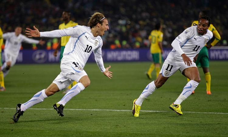 topscorer. Med et langskud og et straffespark er Diego Forlán (tv.) nu topscorer ved VM. 