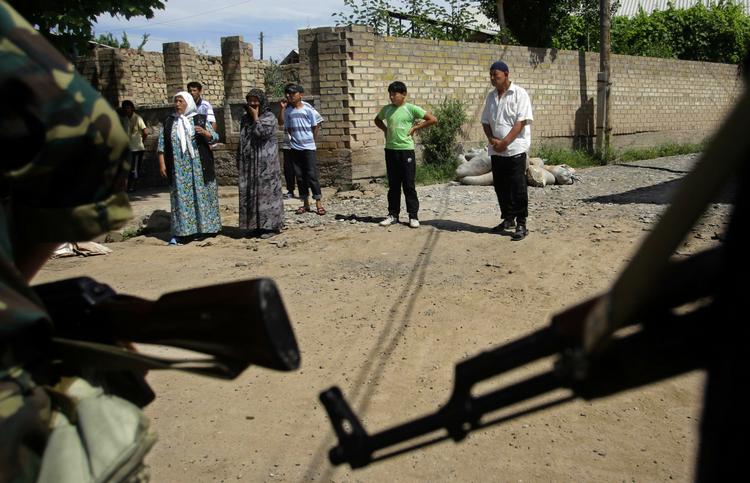 PATRULJE. Usbekere i den kirgisiske by Jalalabad ser til, mens soldater patruljerer i gaden. 