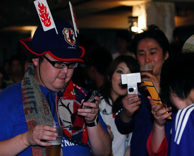 tweets. Japanske fodboldfans sender deres rekationer via mobil til Twitter, da Japan scorede mod Cameroun. Japan er en af de nationer, hvor flest mennesker gør brug af Twitter. Arkivfoto. 
