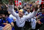 Tokyoglæde. Japanske fodboldfans fejrer knockout-sejren over Danmark i de tidlige morgentimer i den japanske hovedstad Tokyo. 