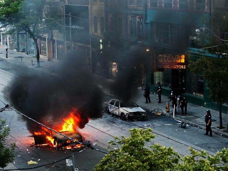 Uro. Der blev brændt biler af og smadret butiksvinduer ved nattens demonstration i Toronto. 150 mennesker er blevet anholdt. 