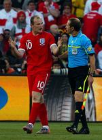 skandale. Englands Wayne Rooney viser med let afkodeligt kropssprog dommer Jorge Larriondo, hvor langt inde bolden var, selv om dommeren ikke dømte mål. 