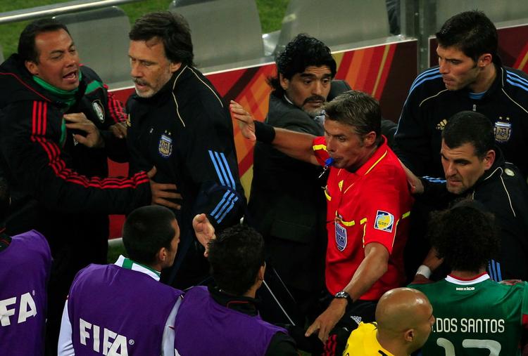 KONFLIKTLØSER. Dommer Roberto Rosetti måtte i pausen af kampen mellem Argentina og Mexico lægger sig imellem spillere og trænere fra de to hold. 