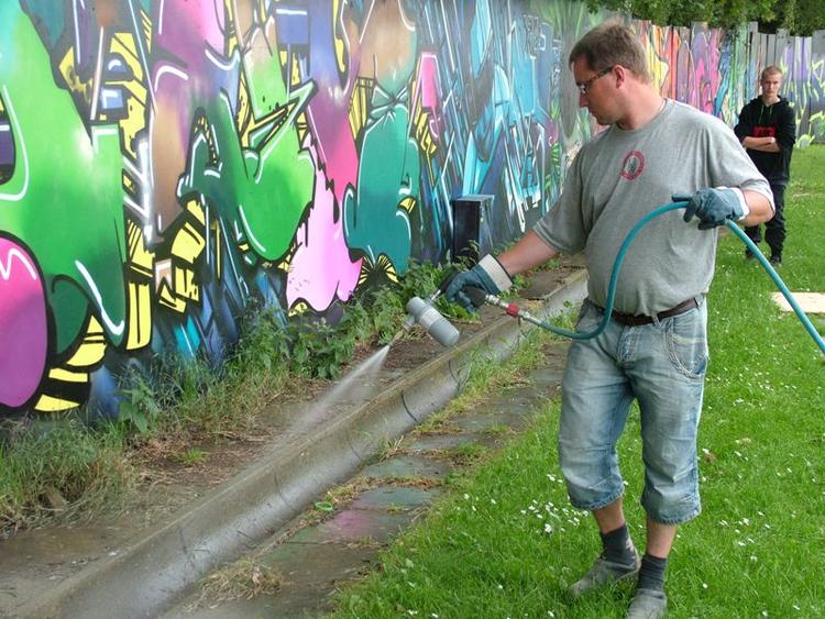 Urinbekæmpelse. Ny amerikansk opfindelse skal komme festivalgæsternes sarte næser til gavn. Her er en medarbejder fra RTR (Renovations Transport Roskilde) i sving med pistolen. 