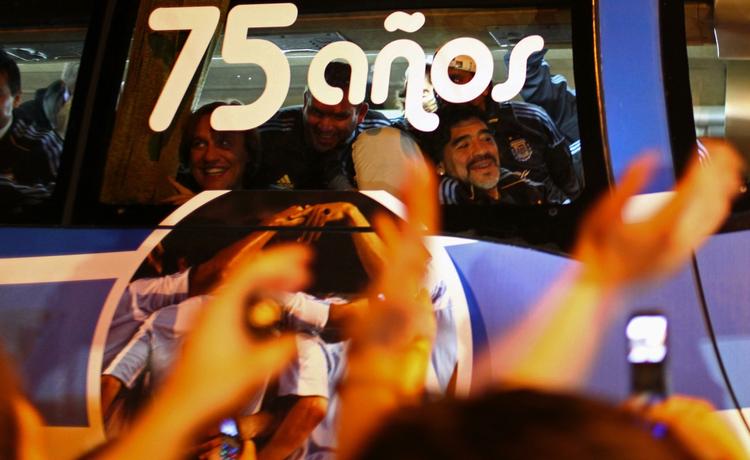 hjemkomst. Argentinas landstræner Diego Maradona smiler gennem ruden i bussen, da holdet blev hjerteligt modtaget i Buenos Aires. 