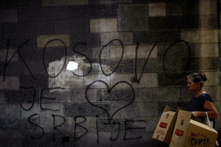 SELVSTÆNDIGHED. En kvinde går forbi noget graffiti med ordene »Kosova er hjertet af Serbien«. 