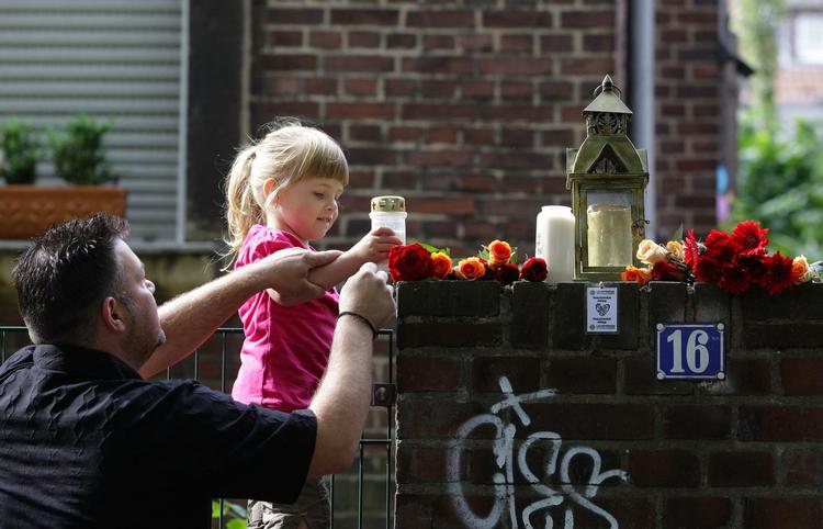 Minde. Gina-Marie tænder - med hjælp fra sin far - et lys for de 19 ofre og mange tilskadekommende. 
