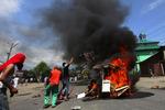 Brand. Muslimer fra Kashmir kaster møbler og sten på en af myndighedernes brændende biler. 