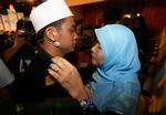 Imamreality. 26-årige Muhammad Asyraf Ridzuan, til venstre, gik hele vejen og vandt realityshowet 'Imam Muda'. Her får han et knus af sin stolte mor. 