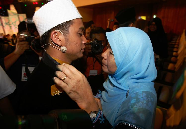 Imamreality. 26-årige Muhammad Asyraf Ridzuan, til venstre, gik hele vejen og vandt realityshowet 'Imam Muda'. Her får han et knus af sin stolte mor. 