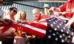 flagafbrænding. Liverpool-tilhængere brænder amerikanske flag af uden for hjemmebanen Anfield i en protest mod klubbens ejere. Arkivfoto. 