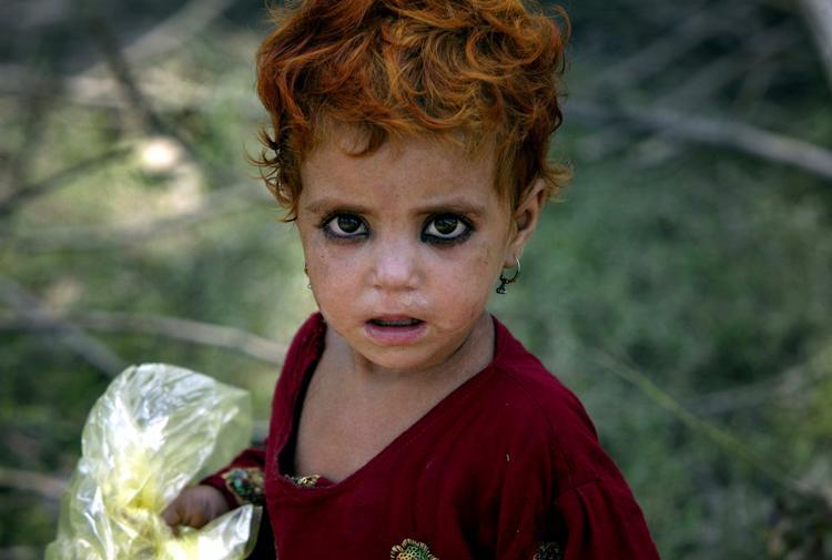En lille pige står udenfor det telt hun deler med sin familie i en lejr udenfor Charsadda i det nordvestlige Pakistan. 