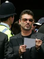 Fedtefadet. Den 47-årige George Michael kommer for retten i London 24. august, efter at han i bil i sidste måned vædrede en fotobutik i det nordlige London. 