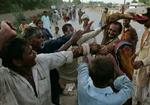REGNVAND. Regeringen i Pakistan forventer kraftig regn de næste dage. Her kæmper pakistanere om nødhjælp, der bliver leveret ud. 