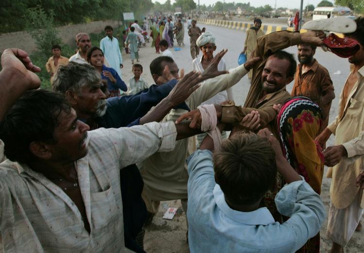 REGNVAND. Regeringen i Pakistan forventer kraftig regn de næste dage. Her kæmper pakistanere om nødhjælp, der bliver leveret ud. 