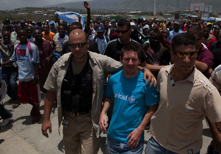 unicef-ambassadør. Lionel Messi brugte noget af sin korte sommerferie efter VM på et besøg til nogle af de hårdt ramte områder efter jordskælvet i Haiti. Her føres han gennem menneskehavet af to bodyguards. Arkivfoto. 