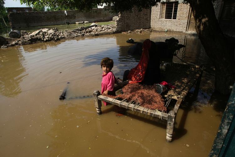 oversvømmelse. En lille pige sidder foran det, der var familiens hjem i Khangarh nær Multan i Pakistan. 