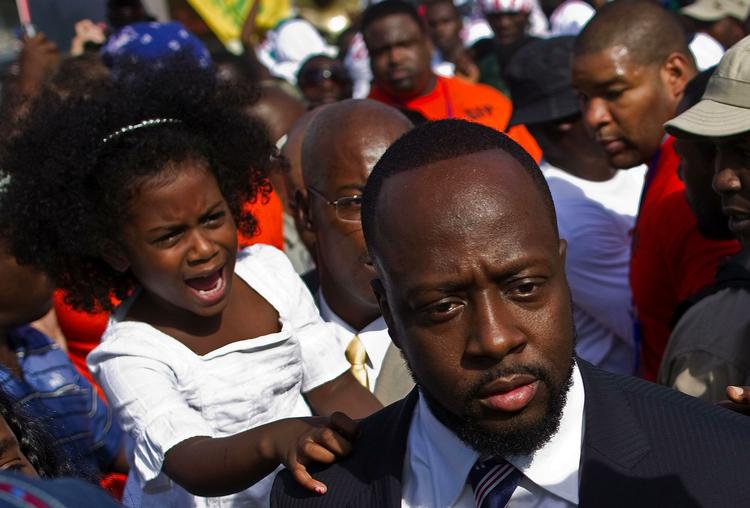 Efterstræbt. Wyclef Jeans datter Angelina jean, tv, rækker ud efter sin far, da han tidligere på måneden ankommer til et valgkontor for at meddele sit kandidatur til præsidentembedet i Haiti. 