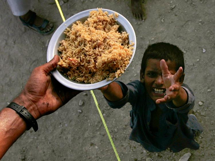 nødhjælp. En dreng modtager et måltid mad i en midlertidig lejr for ofre for oversvømmelserne i Sukkur i det sydlige Pakistan. 
