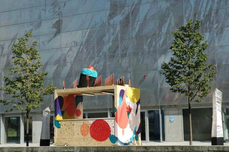 Kunstnergruppen Ultra Grøn har malet facaden på værftet, mens kunstneren Karen Kaster har stået for kage-installationen på taget. 