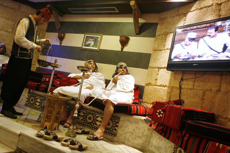 Nostalgi-trip. I sin femte ramadan-sæson er 'Bab al-Hara' en af de mest populære sæbeoperaer i den arabiske verden. Her er det to vand- piberygende libanesere, som følger  serien i et tyrkisk bad i Beirut. Foto: Khalil Hassan/Reuters 