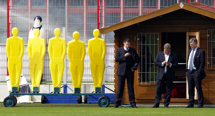 modangreb. Bayern Münchens mediedirektør Markus Hörwick tjekker sin mobiltelefon mellem to Uefa-repræsentanter på træningsanlægget før kampen i aften mellem Bayern og Roma. 