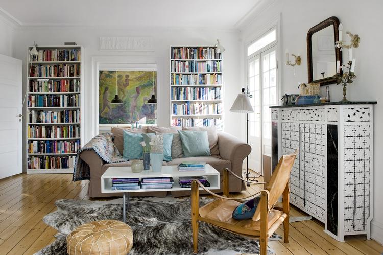 Nyt og gammelt. Den store stue har parret indrettet med ens reoler for at få plads til alle deres bøger. Sofa og sofabord er fundet hos Ikea, som Anna Johansen har piftet op med puder af Liberty-stoffer, som hun selv har syet.