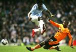 arresteret. Titus Bramble i Wigan-trøjen tackler Manchester Citys angriber Emmanuel Adebayor. Arkivfoto. 