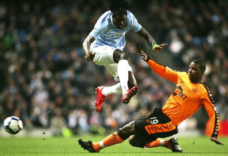 arresteret. Titus Bramble i Wigan-trøjen tackler Manchester Citys angriber Emmanuel Adebayor. Arkivfoto. 
