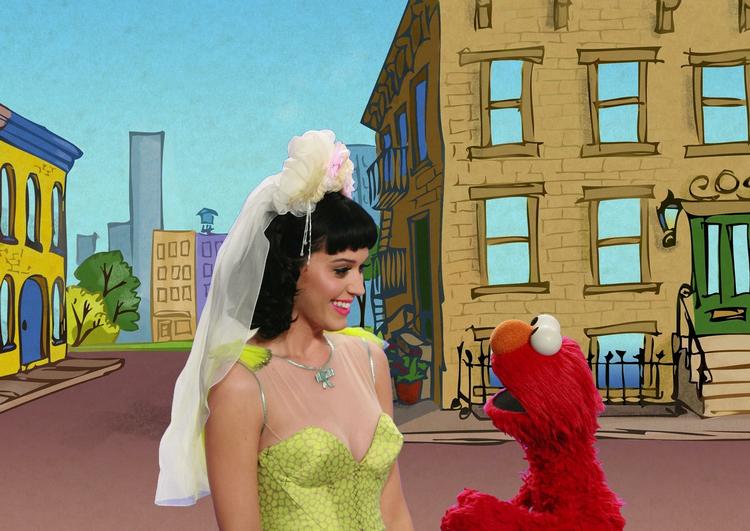 Gemmeleg. Katy Perry vil bare så gerne lege med Elmo, men den behårede døgenigt bliver ved at stikke af - forstå det hvem der kan. 