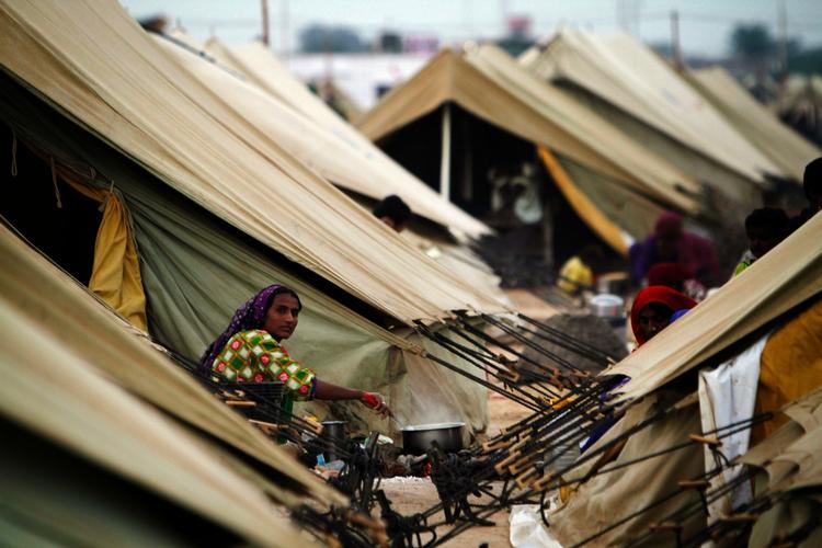Midlertidigt. Mange pakistanske familier lever lige nu i teltlejre som denne i Thatta. Regeringen tilbyder nu familierne penge for at vende hjem. 