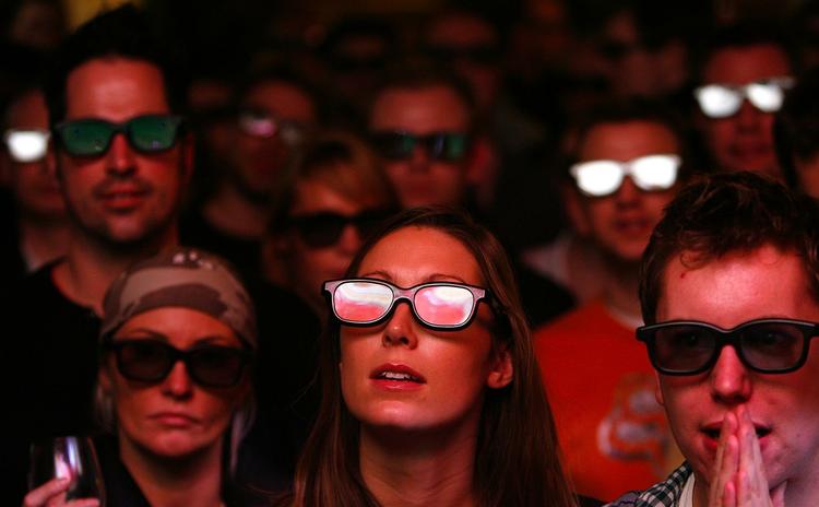 Med eller uden 3D-briler. Det er spilfirmaerne ikke enige om. Personerne her på billedet ser fodboldkampen mellem Arsenal og Manchester United, der blev vist i 3D. 