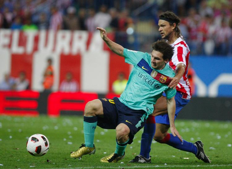 Av. Lionel Messi (i blåt) blev tacklet hårdt af Atletico Madrids tjekke Tomas Ujfalusi. 