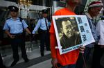dømt. Demonstranter protesterer over den dom på 11 års fængsel, som den kinesiske demokratiforkæmper Liu Xiaobo fik sidste år. 