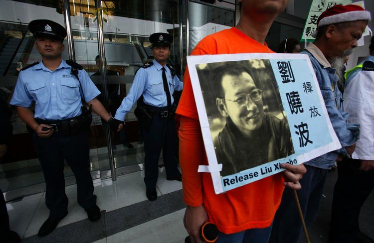 dømt. Demonstranter protesterer over den dom på 11 års fængsel, som den kinesiske demokratiforkæmper Liu Xiaobo fik sidste år. 