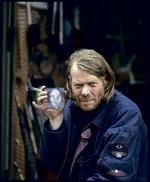 William Skotte Olsen. Født 1945. Død 2005. I sine sidste år malede han i et hæsblæsende tempo. Blandt andet et hav af portrætter på bølgepap, tagplader eller andre former for affald, han fandt. Foto fra udstillingskataloget: Simon Lautrop 