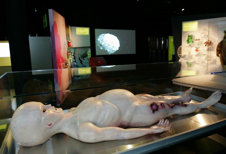 Snyyydt! Hvad hulen skal vi gøre, når de pludselig står her? I Hollywoods verden lander de altid i nærheden af Washington og præsidenten, men det er slet ikke ham, der skal byde velkommen. Forlød det. Den historie kunne pressen godt lide. Her er vi på Miami Museum of Science and Planetarium, hvor en figur fra filmen 'Alien Autopsy' er udstillet. 