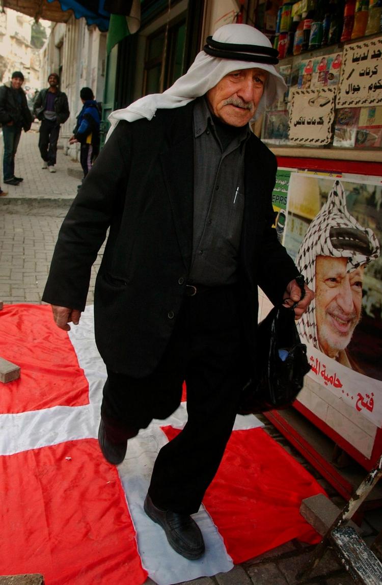 En palæstinensisk mand viser 29. januar sin foragt for Danmark ved at træde på Dannebrog i byen Nablus på Vestbredden. 