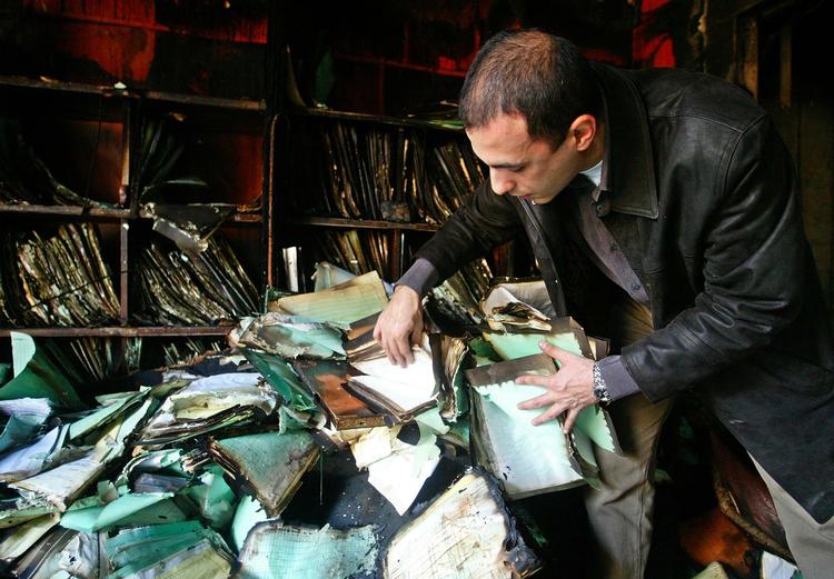 En libanesisk ansat gennemgår brændte papirer på konsulatet i Beirut dagen efter angrebet. 